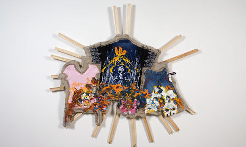 Multicolored material hanging on approx. 16 wood bars