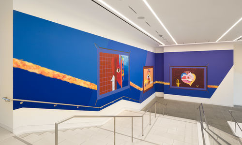 Mural on a bright blue background, installed along a large museum stairway