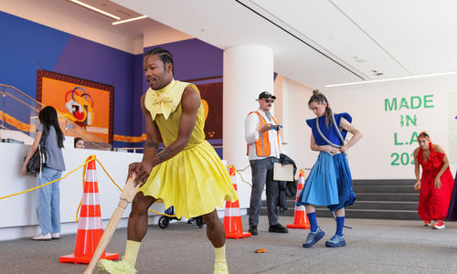 Brightly dressed dancers in the lobby of the Hammer Museum