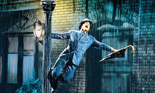 Gene Kelly spins around a lamppost in the rain