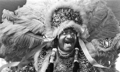A man in an ornate beaded headdress and costume