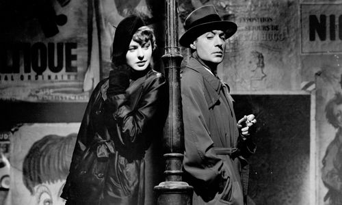 Ingrid Bergman and Charles Boyer stand back to back, a lamppost between them