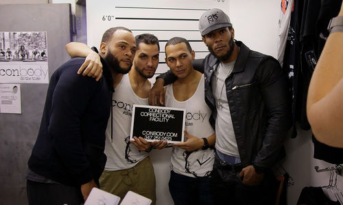 Four men pose with a sign reading "Conbody Correctional Facility"