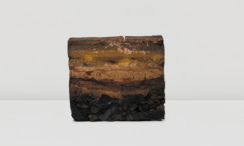 Striated block of compacted natural materials