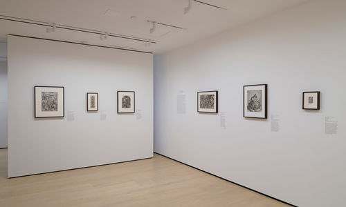 Gallery with framed works on paper mounted on the wall