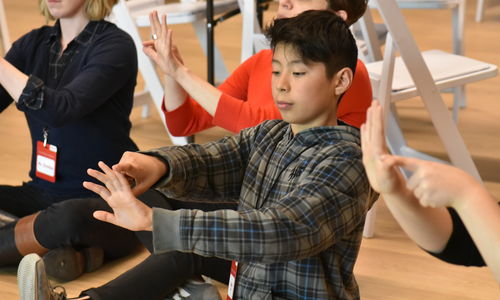 Children seated at the Hammer, practicing hand movements.