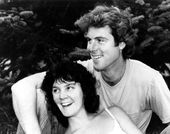 Still from the film Return of the Secaucus Seven (1979) showing a woman leaning against a man, both seated and smiling