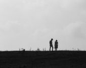 Still from the film Spring Night, Summer Night (1967) showing two people standing on a hill, in shadow