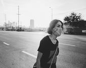 Still from the short film "Last Light" (2020) by Carmen Argote, showing a woman in a protective face mask walking down a Los Angeles road