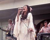 A woman in a white dress singing on stage in a still from the film "Nashville" (1975)