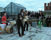 The Beatles perform on a rooftop in a still from the film "The Beatles: Get Back" (2021)