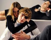 Girl holds boy wearing eye patch