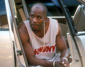 Man leans out of car door wearing gold chain