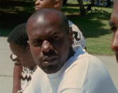 Man looks at man while both sit in a public park