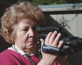 An elderly woman holds a video camcorder