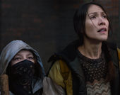 Two women, one wearing a bandana over her face
