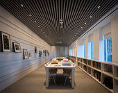 Empty room with tables and walls covered in works on paper
