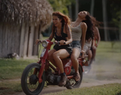 image of two people with long hair riding motorcycle