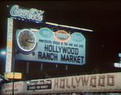 Large billboard sign with a clock reading: We Never Close - Hollywood Ranch Market"