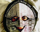 Photo of David Medalla wearing a mask that reads "in conversation with the cosmos"